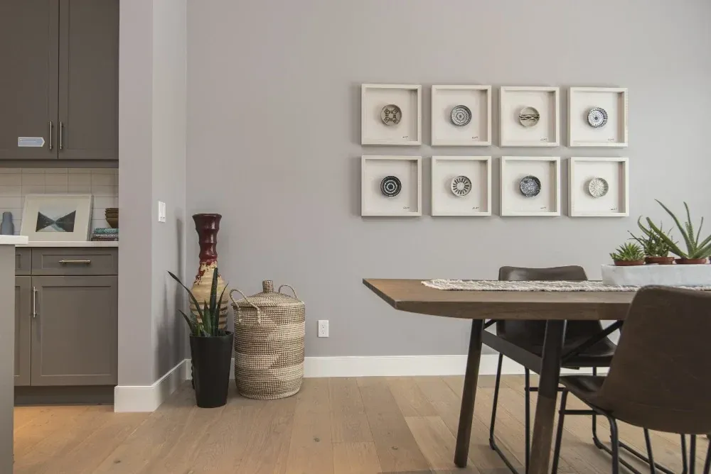 Staged dining area with a wood table, framed wall art, and neutral decor