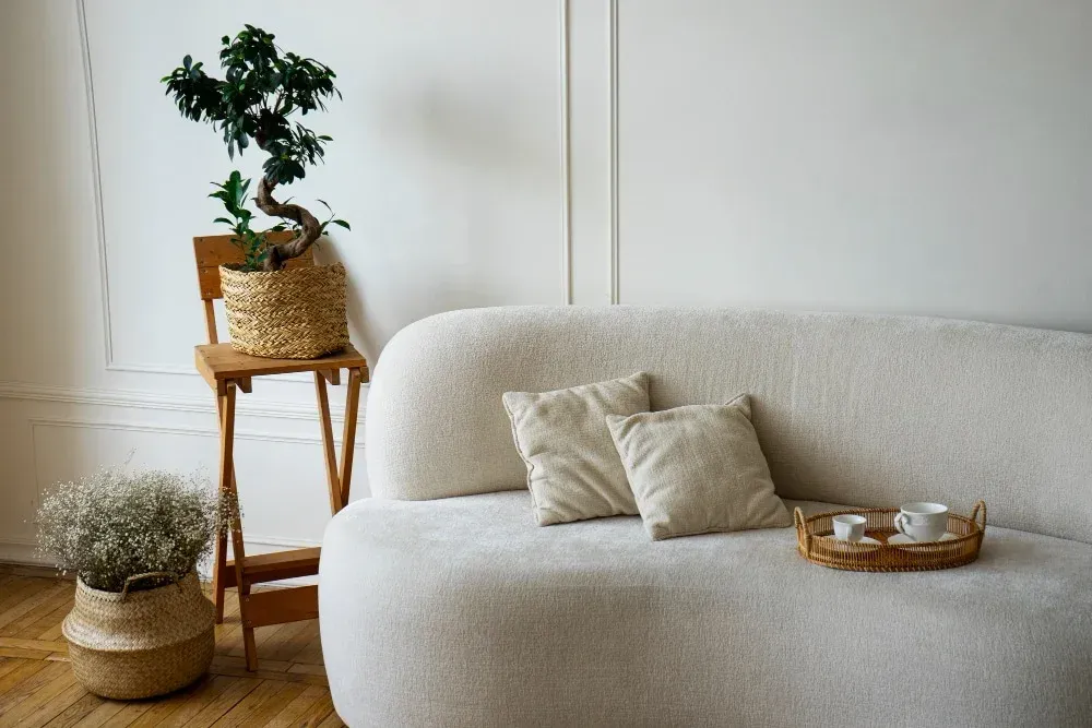Staged living room with a cream sofa, throw pillows, and woven baskets