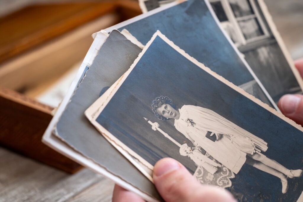 hands sorting through old family photographs from a keepsake box during estate downsizing, Winchester VA