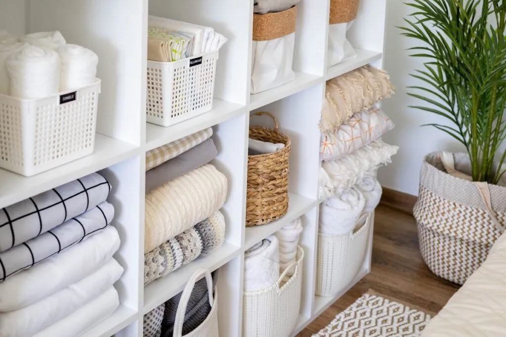 neatly organized shelves with folded linens and labeled baskets, professional home organizing in Winchester VA