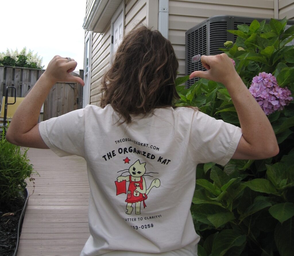 Eve wearing The Organized Kat t-shirt with the logo and website on the back, professional home organizing in Winchester VA