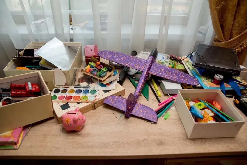 Jumble of colorful kids' toys and art supplies piled in an open box