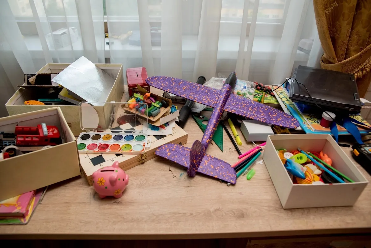 Jumble of colorful kids' toys and art supplies piled in an open box